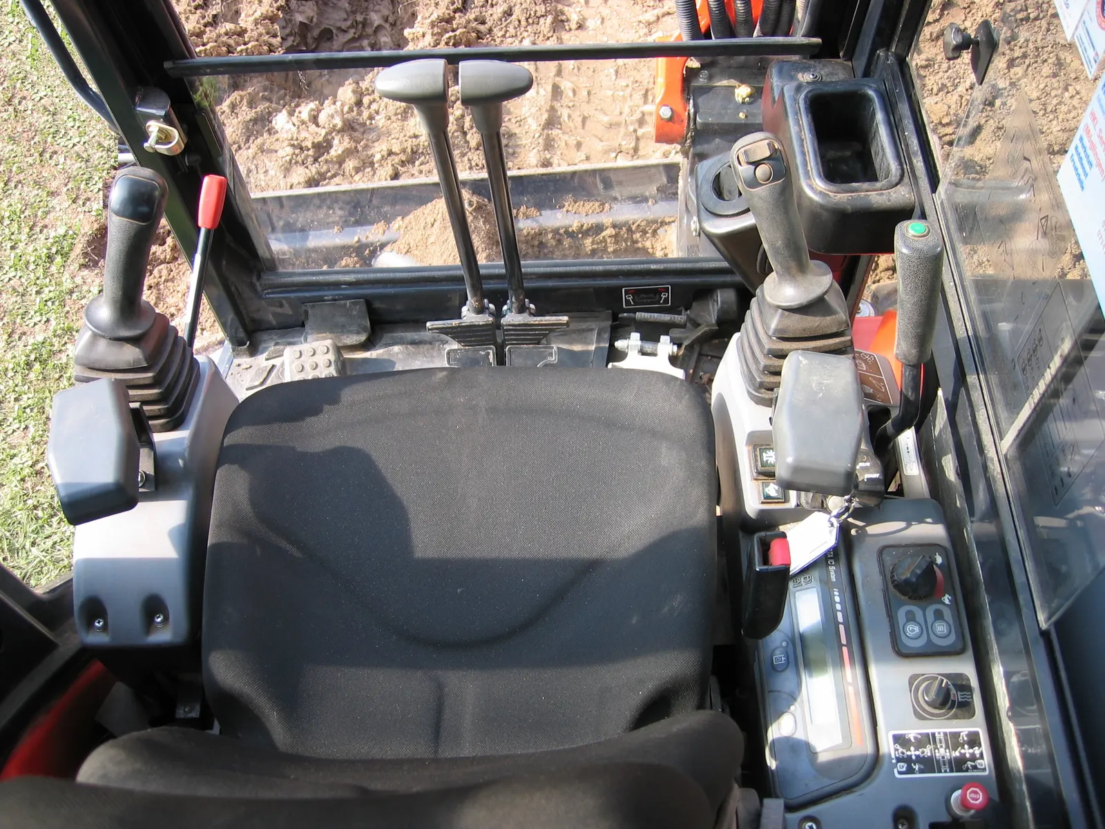 Manual controls in an excavator cab — illustrative; this is a conventional machine, not the MIT interface. Photo: Hans Haase/Wikimedia Commons (CC BY-SA 4.0)